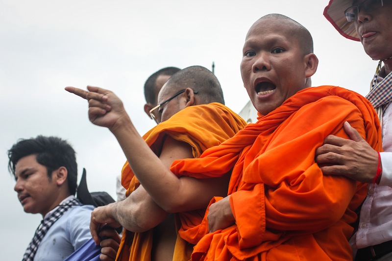 Soeung Hai shouts from atop a post demarcating the boundary between Cambodia and Vietnam in Svay Rieng province during an opposition-led protest in July. (Alex Willemyns/The Cambodia Daily)